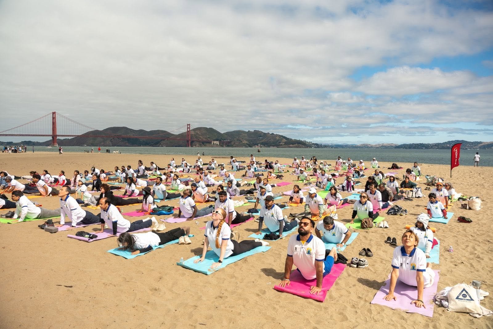 Where the Pacific meets the pose — Yoga at the Golden Gate.  On June 20, 2026, @CGISFO marked the 12th #InternationalDayofYoga2026 at Crissy Field East Beach, San Francisco, against the magnificent backdrop of the iconic Golden Gate Bridge emerging through the morning fog.
