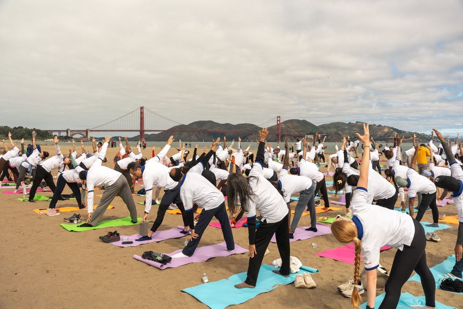 Where the Pacific meets the pose — Yoga at the Golden Gate.  On June 20, 2026, @CGISFO marked the 12th #InternationalDayofYoga2026 at Crissy Field East Beach, San Francisco, against the magnificent backdrop of the iconic Golden Gate Bridge emerging through the morning fog.