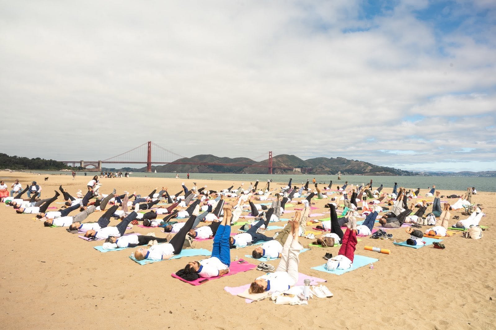 Where the Pacific meets the pose — Yoga at the Golden Gate.  On June 20, 2026, @CGISFO marked the 12th #InternationalDayofYoga2026 at Crissy Field East Beach, San Francisco, against the magnificent backdrop of the iconic Golden Gate Bridge emerging through the morning fog.